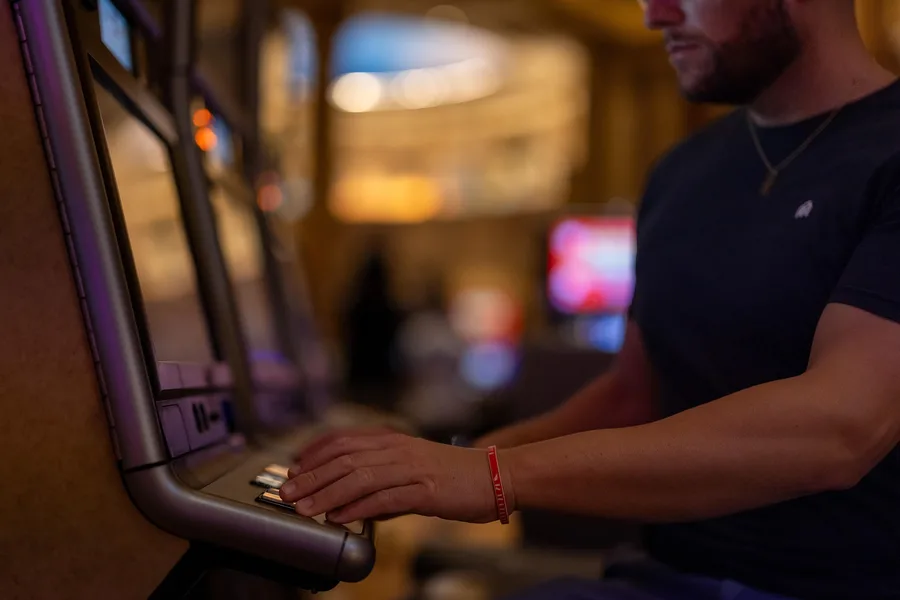 Speler drukt op de knoppen van een gokkast in een casino